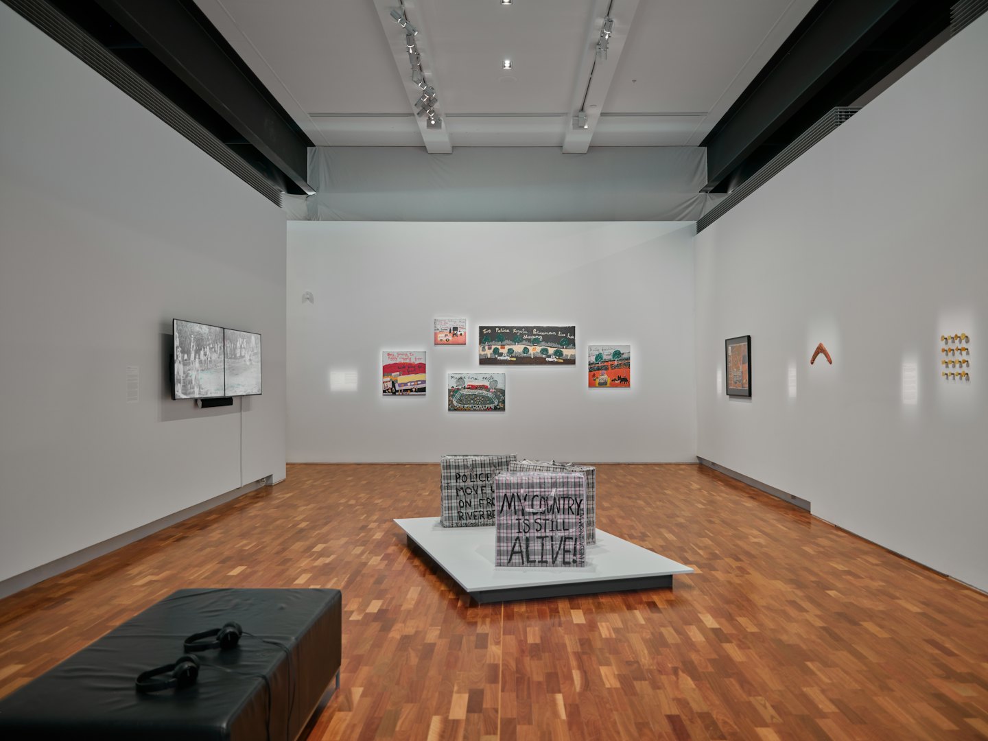 Modern art gallery with diverse sculptures and video installations.